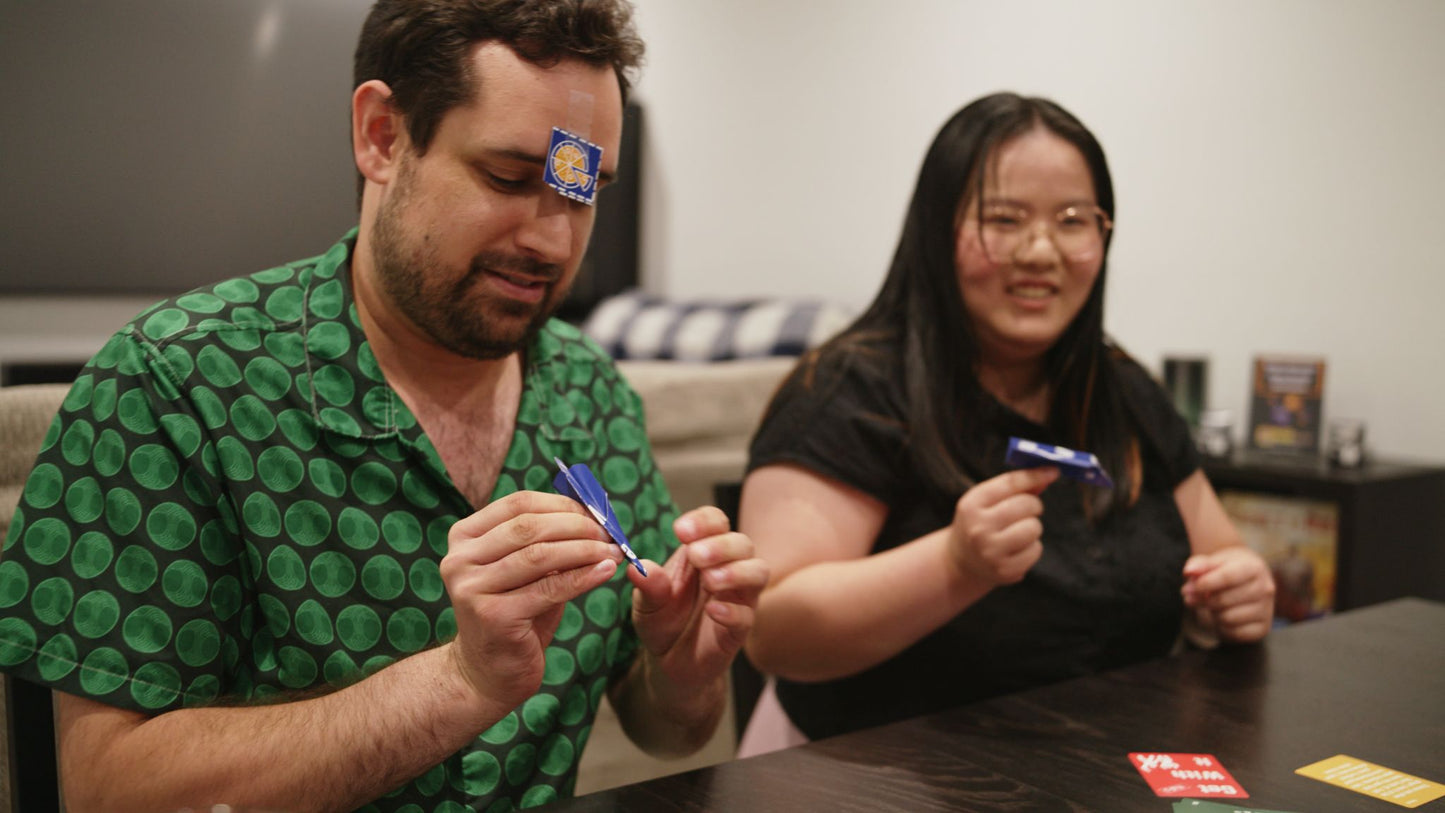 People creating paper airplanes while playing Get With It
